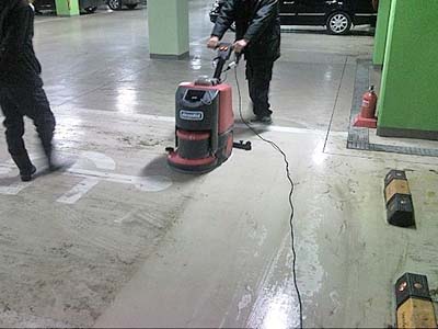 주차장에서 이동식 스크리버를 사용하여 바닥 때를 지워냅니다.